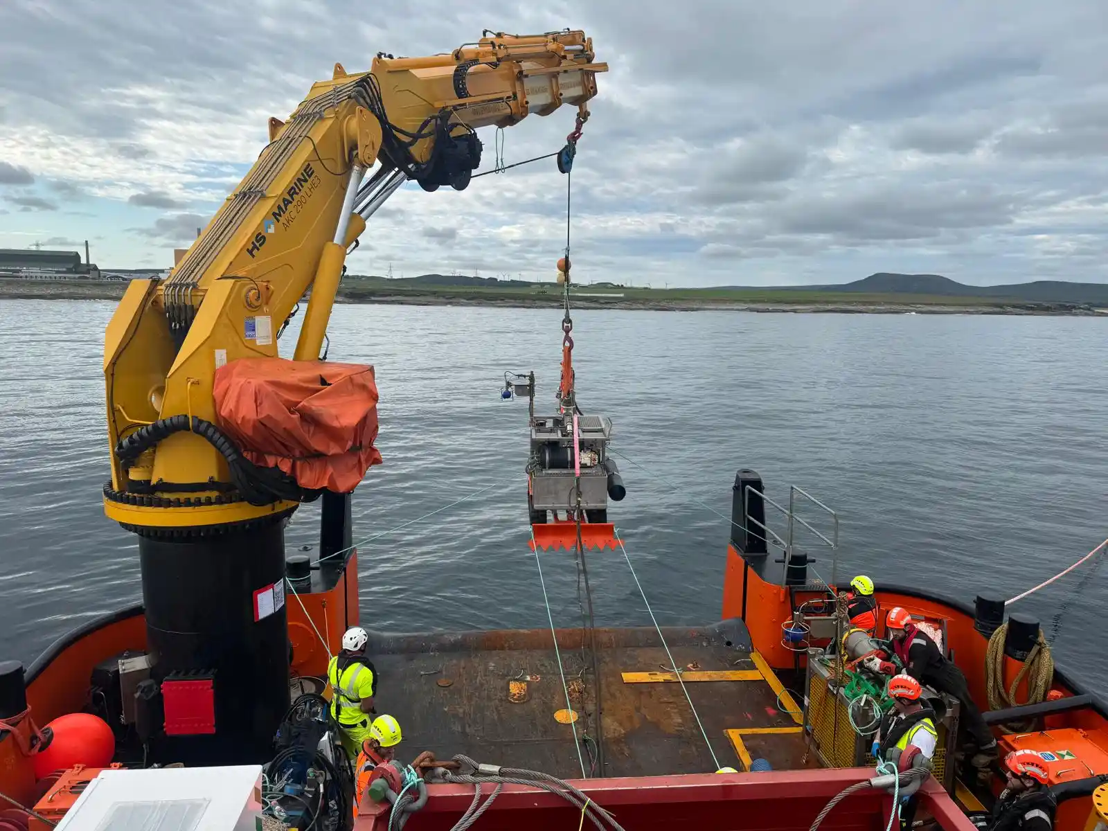 Deck crew lifting subsea equipment over the side during an offshore operation